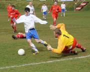 Veteran Wadebridge keeper Mark Gears dives at the feet of  Camelford's Alex Ahearn.